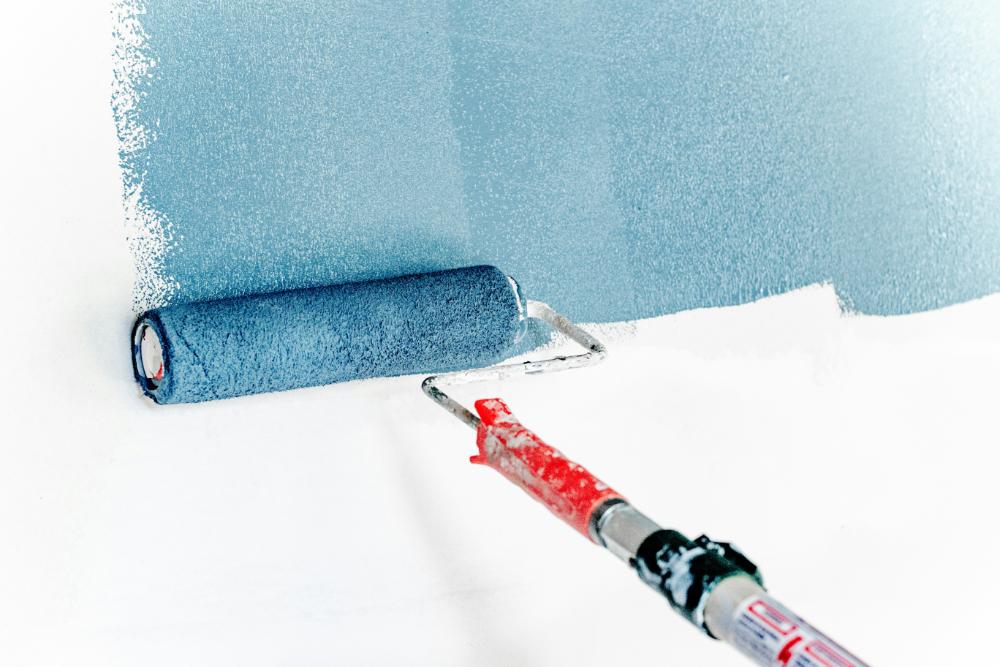 Farbwalze mit blauer Farbe an Wand, Mita-On GmbH
